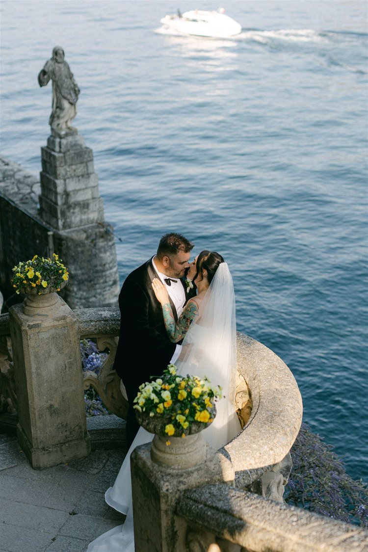 A kiss beside a statue, above the lake