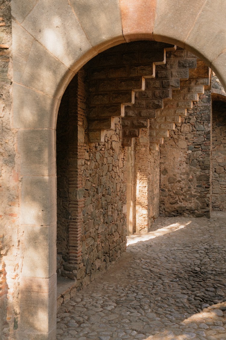 Stone archway and brick staircase detail inside the grounds of Bellesguard Tower, a Gaudí building in Barcelona