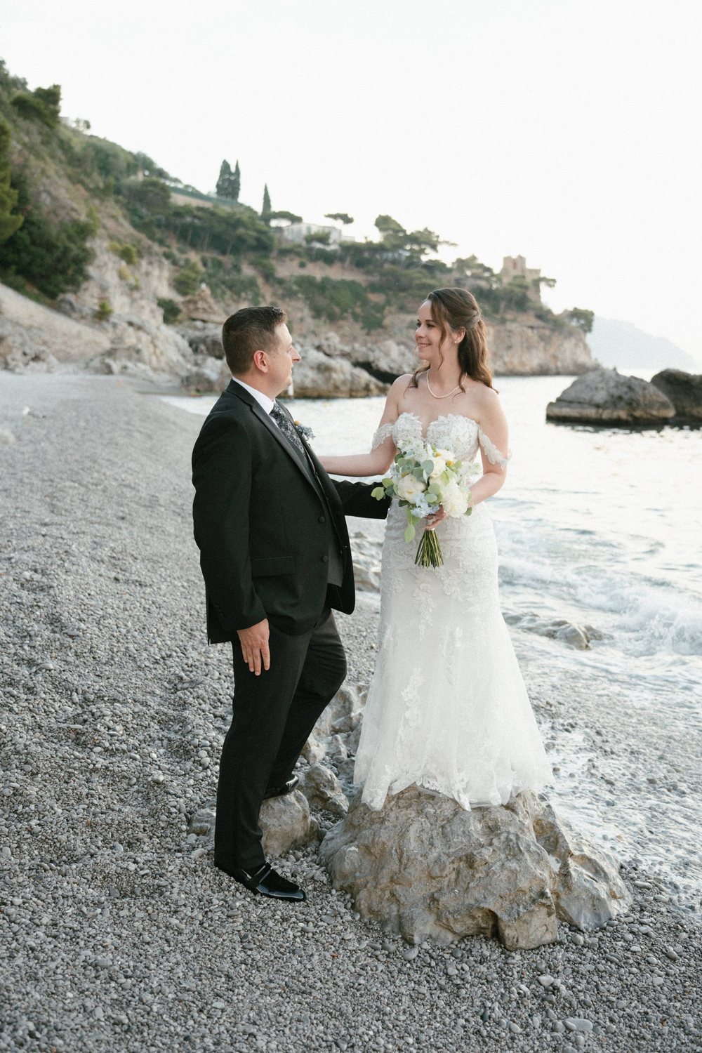 A couple on the pebble beach, with the cliffs behind