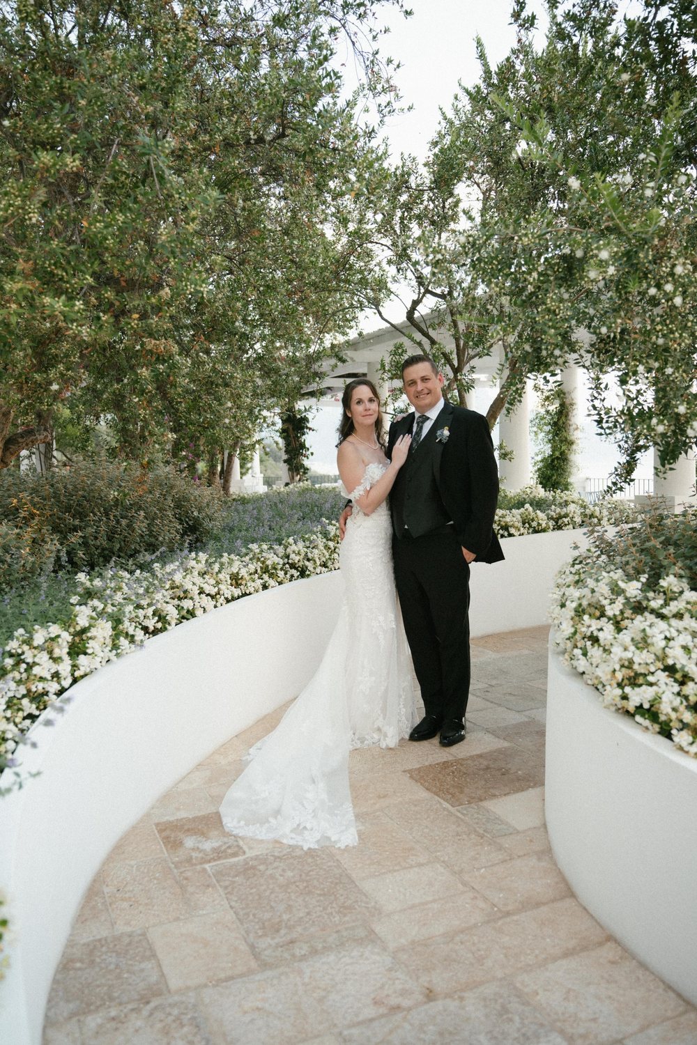 A couple on a garden path lined with white flowers