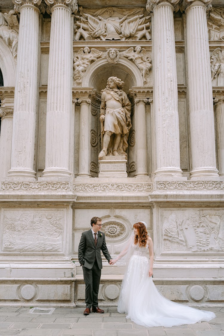 A couple in front of a marble facade in Venice