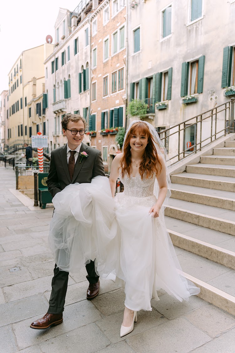A groom carrying his bride down a Venetian street