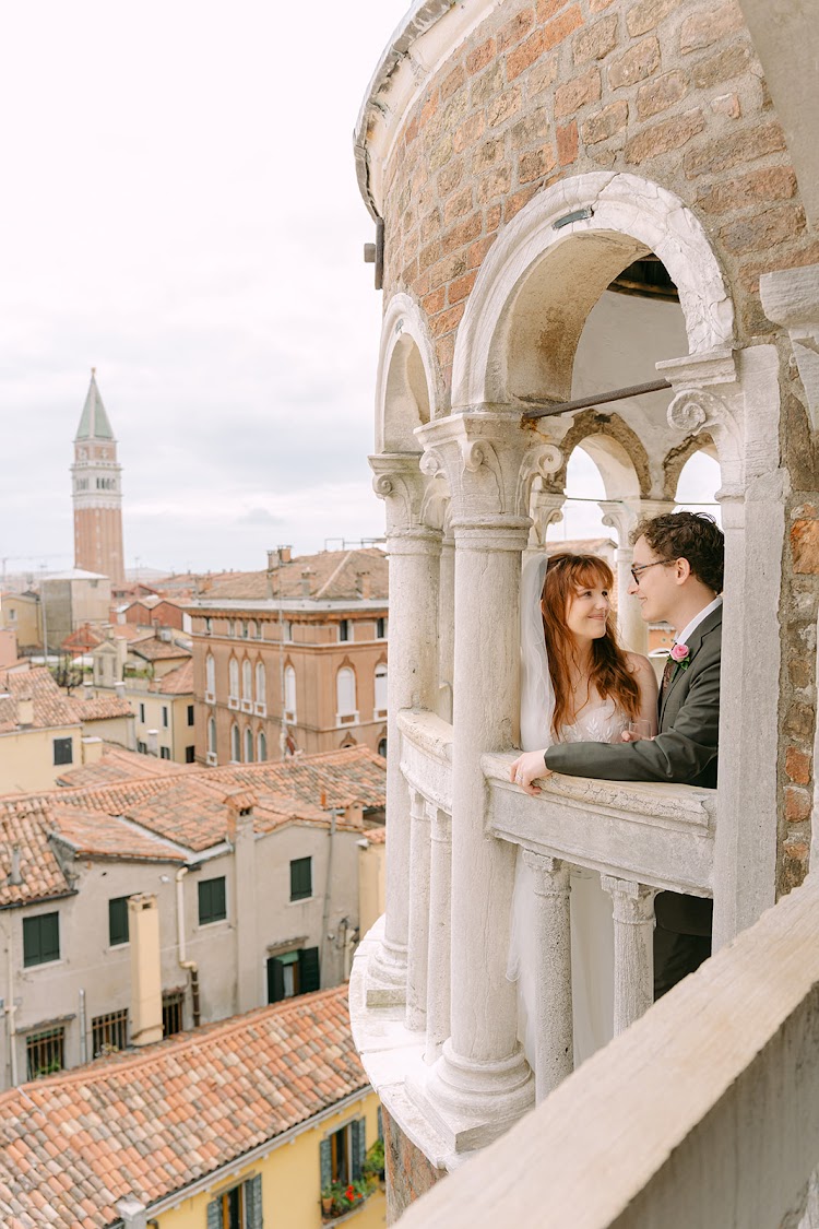 A couple in a window of the tower, with St Mark’s bell tower beyond