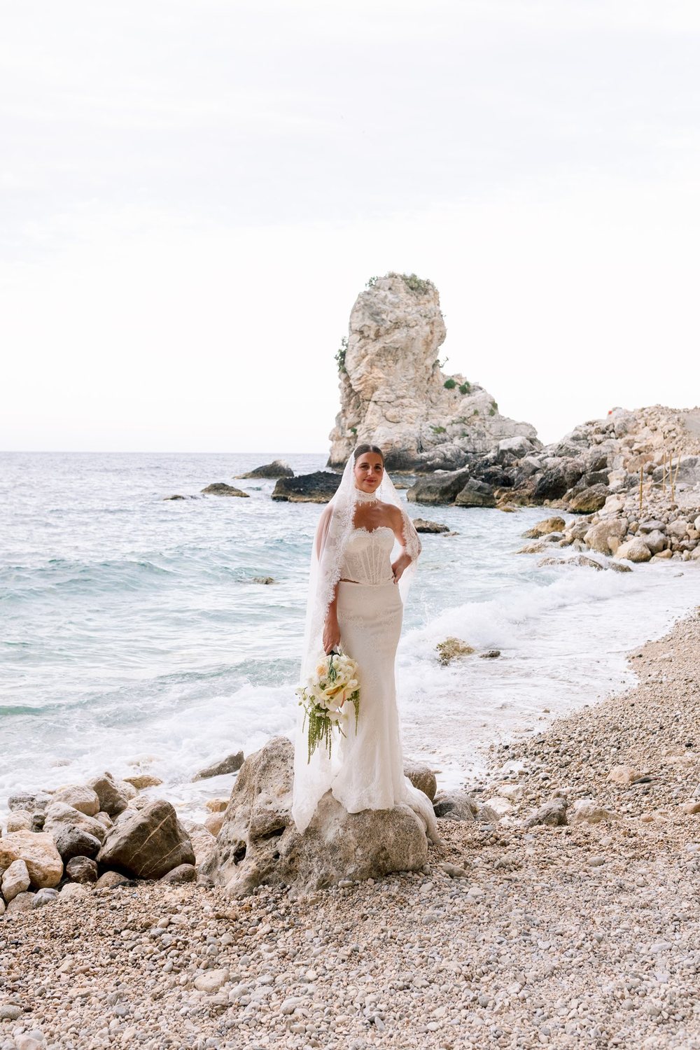 A bride on the rocks by the sea