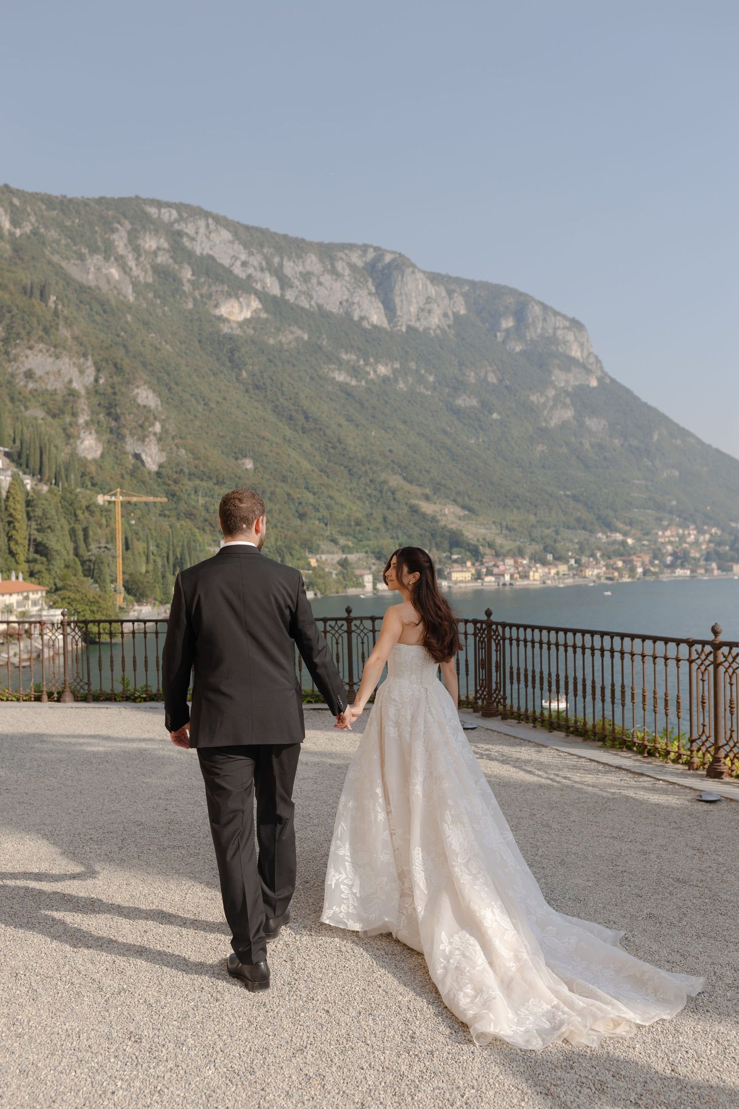 A couple walking along the lakeside terrace at Villa Cipressi