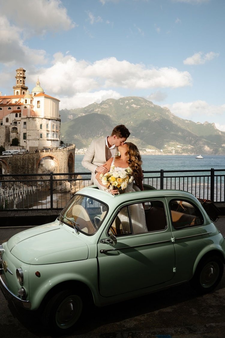 A vintage Fiat 500 parked above the sea