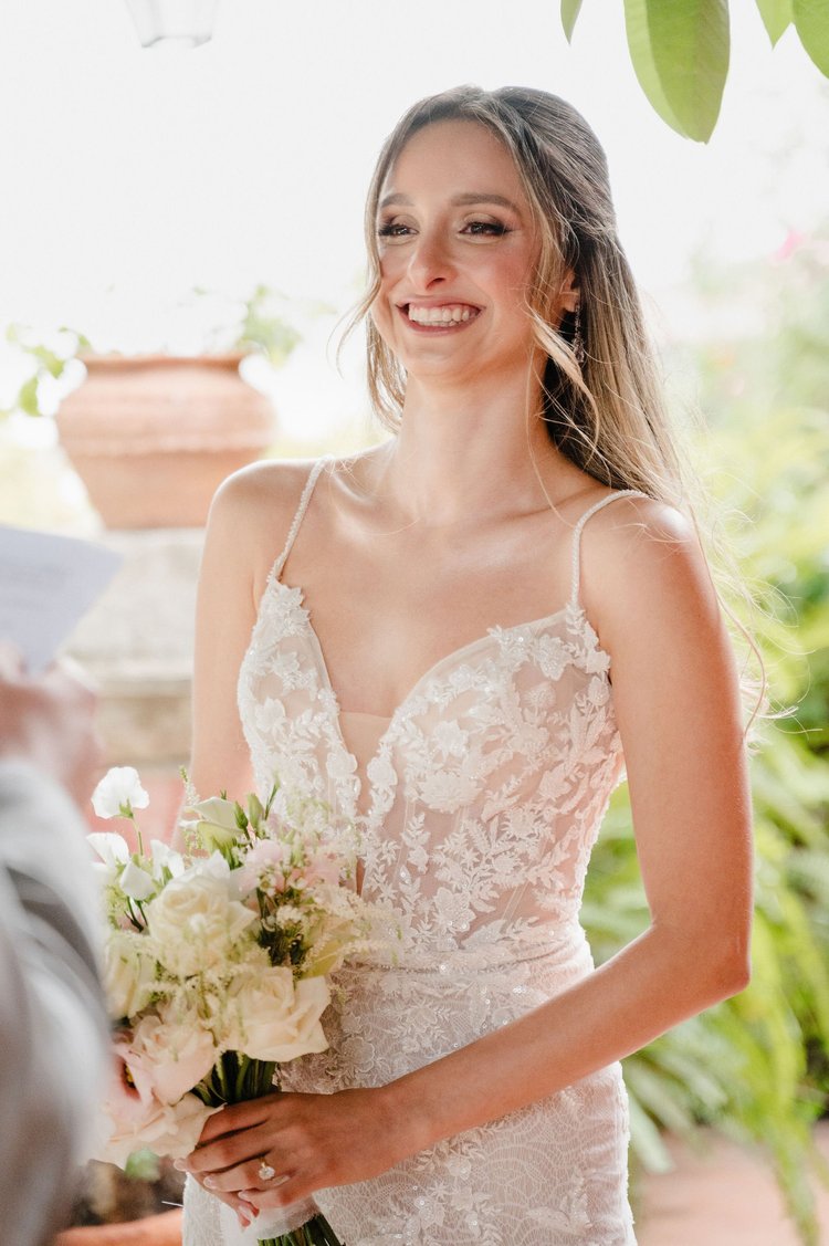 A smiling bride holding her bouquet during an elopement in Sicily
