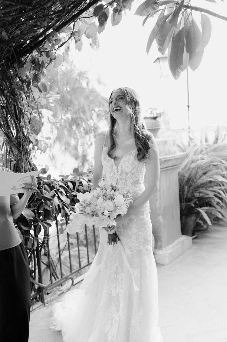 A bride in black and white surrounded by greenery during her elopement in Sicily