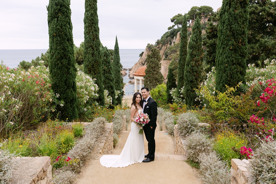A couple walking along a garden path with the Linnaeus Temple behind them, Marimurtra Botanic Gardens, Costa Brava