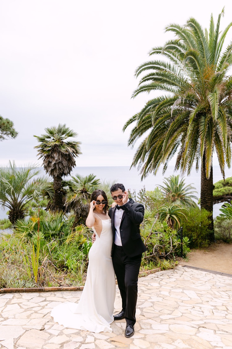A bride and groom among palm trees in Marimurtra Botanic Gardens, Blanes, Costa Brava