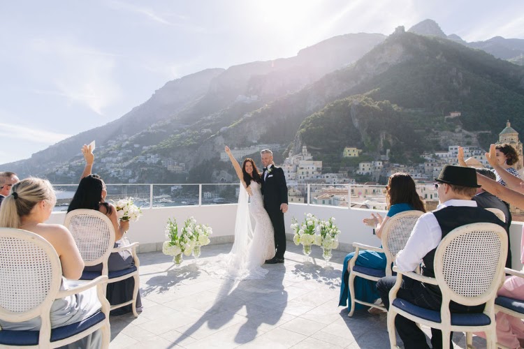 Bride cheering with her arms raised after an elopement ceremony on the terrace of Hotel Marina Riviera on the Amalfi Coast, Amalfi