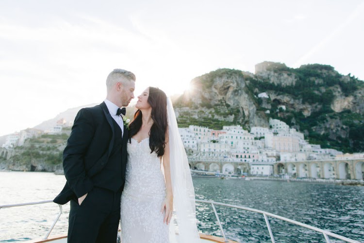 Bride and groom kissing on a private boat along the Amalfi Coast after their elopement at Hotel Marina Riviera on the Amalfi Coast