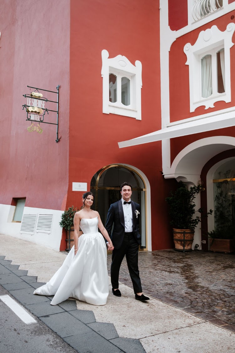 A couple in front of a red facade in Positano