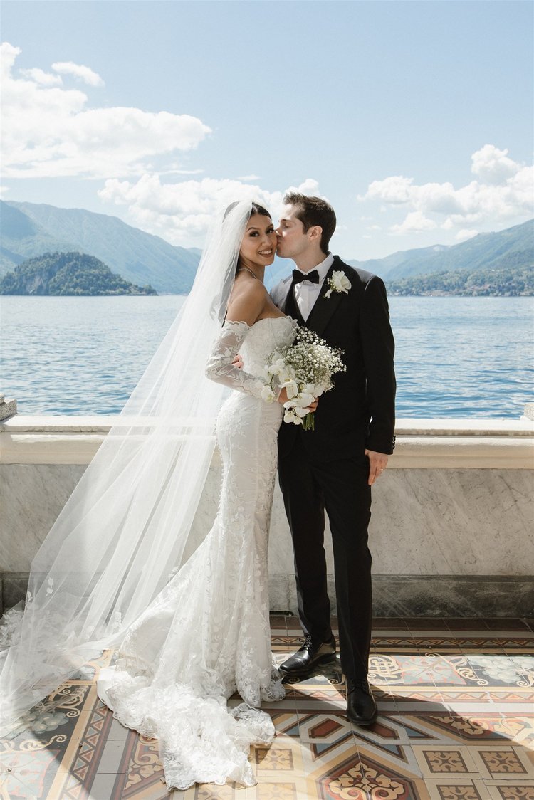 A couple on the balcony of Villa Monastero, with the lake behind