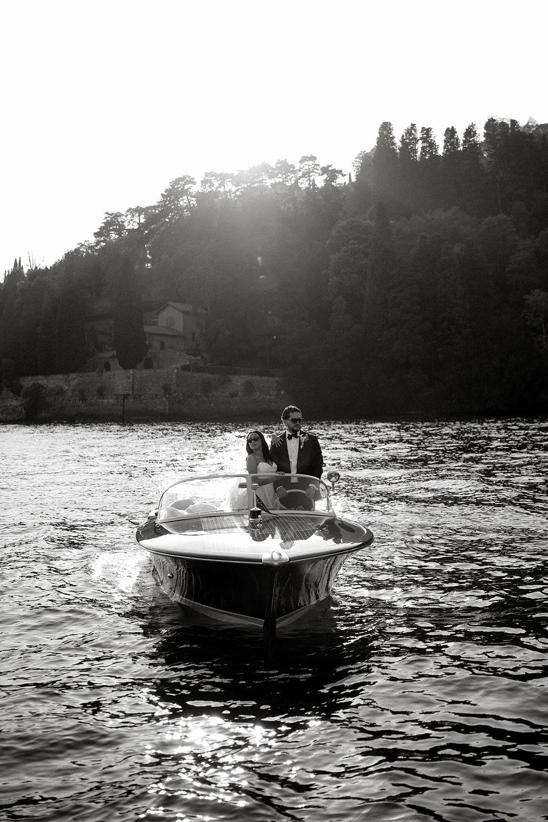 A black and white view of a couple on a boat on Lake Como