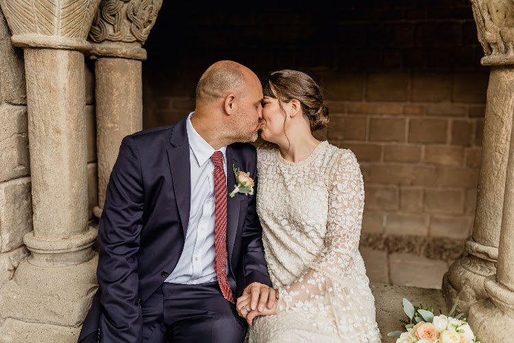 A couple kissing while seated in the arches of the monastery cloister at Poble Espanyol in Barcelona