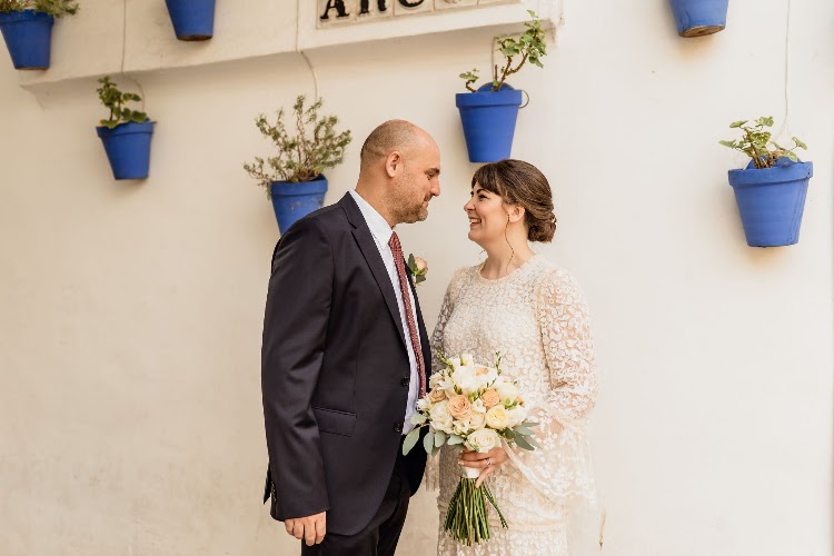 A couple beside a whitewashed wall with blue flower pots in the village at Poble Espanyol in Barcelona