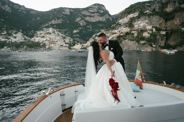 A couple on a private boat, with Positano behind