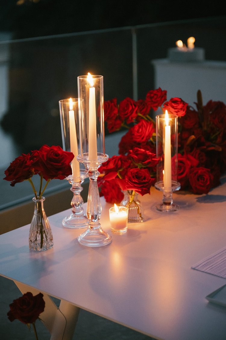 Candles and red roses on the dinner table
