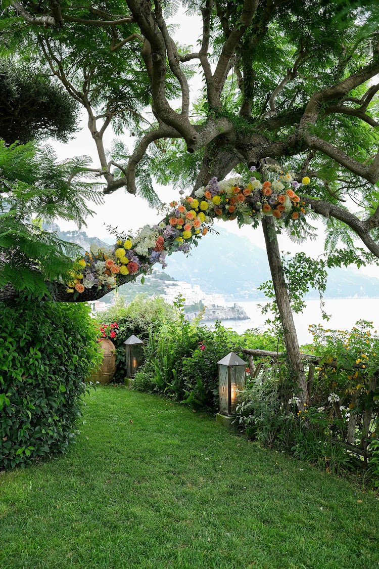 The flower-draped ceremony arch in the private garden corner of Hotel Santa Caterina on the Amalfi Coast, with sea views